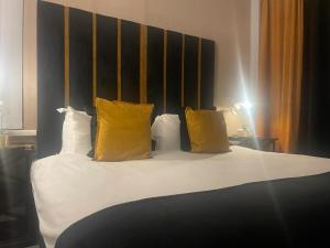 伯明翰Luxury 9ine Lush Jacuzzi Apartment with Balcony的一间卧室配有一张带黄色枕头的床