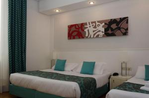 罗马图拉真酒店的酒店客房设有两张床,墙上挂有绘画作品