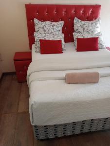 梅富根Rizhatchguest的一张大床,配有红色床头板和红色枕头