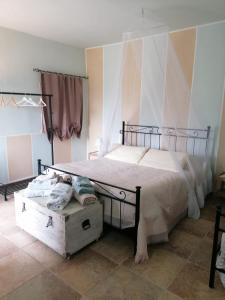 塞尔莫内塔Casale Cavatella的一间卧室配有一张大床和木箱
