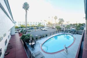 圣地亚哥圣地亚哥机场华美达酒店的享有带停车场的大楼游泳池的正面景色