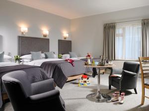 都柏林赫尔伯特山酒店的酒店客房,配有两张床和两把椅子