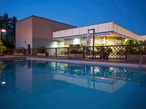 卡塞塔诺富特卡塞塔苏德酒店的建筑前的一座带游泳池的建筑
