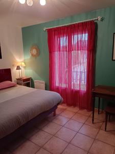 圣保罗三堡Chambres Tricastine & Venise的一间卧室配有床和红色窗帘