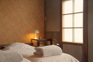 Tamba-sasayamaLhotel de Mai的一间卧室配有一张床,上面有两条毛巾