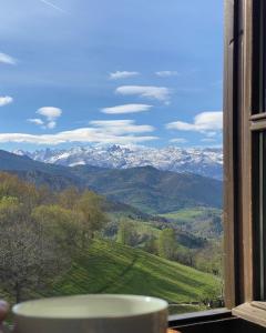 Vibaño魔法山乡村旅馆的窗户享有雪覆盖的山脉美景。