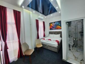 贝尔格莱德Authentic Belgrade Centre - Luxury Suites的一间卧室配有一张床和两把椅子,还有一间浴室