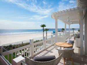 圣地亚哥Shore House at The Del, Curio Collection by Hilton的一个带桌椅和海滩的阳台