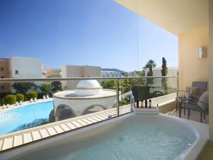 依克希亚The Ixian Grand & All Suites - Adults Only Hotel的浴缸享有泳池美景