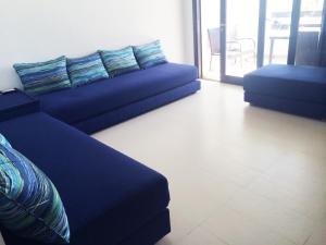卡博尼格洛Apartment Cabo Negro Royal Golf and Resort的一间带蓝色沙发的客厅和一个阳台