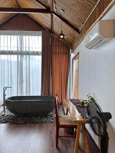 巴位Thang Mây Village Resort的一间带大浴缸和桌子的浴室