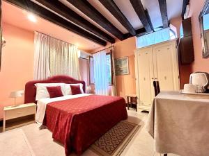威尼斯阿罗吉塞丽娜酒店的一间卧室配有红色的床和红色毯子