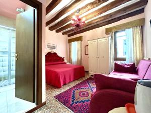 威尼斯阿罗吉塞丽娜酒店的一间卧室配有红色的床和一张沙发