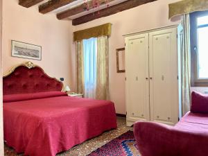 威尼斯阿罗吉塞丽娜酒店的一间卧室设有红色的床和窗户。