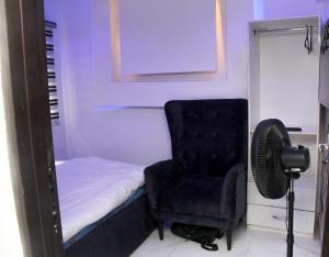 Festac Town3 bedroom apartment (fully furnished), Festac的一间卧室配有一张床、一把椅子和风扇