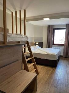 普图伊Hotel Roškar的酒店客房设有两张床和梯子