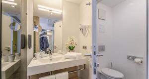 维也纳PLAZA INN Wien Gasometer的白色的浴室设有水槽和卫生间。
