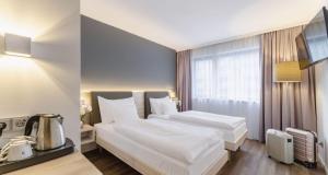 维也纳PLAZA INN Wien Gasometer的酒店客房带一张大床,带白色床单