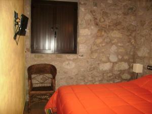 卡索拉Torre Del Inquisidor的一间卧室设有一张床和石墙