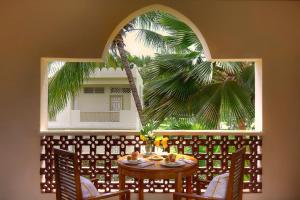 马林迪非洲钻石梦酒店的一间设有桌子和棕榈树的客房
