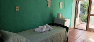 埃尔皮纳尔Hostal Pino Alto的绿色客房 - 带一张带绿色墙壁的床
