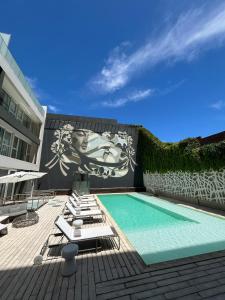布宜诺斯艾利斯伊鲁姆体验家庭酒店的一座带躺椅和壁画的游泳池