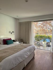 布宜诺斯艾利斯伊鲁姆体验家庭酒店的一间卧室设有一张大床和一个大窗户