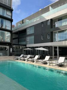 布宜诺斯艾利斯伊鲁姆体验家庭酒店的一座带躺椅的游泳池和一座建筑