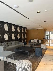 布宜诺斯艾利斯伊鲁姆体验家庭酒店的客厅配有沙发、桌子和墙壁