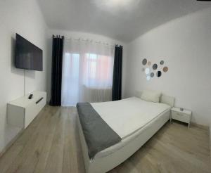 BîrladEnjoy Apartment Barlad的白色的卧室设有床和窗户