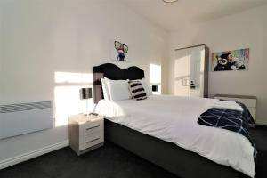 拉纳克Signature - No 1 Bonnet Apartments的一间卧室配有一张白色大床和黑色床头板