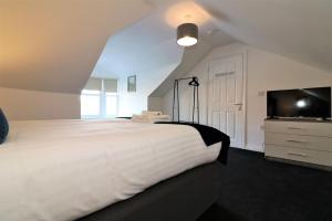 拉纳克Signature - No 7 Bonnet Apartments的卧室配有一张白色大床和电视。