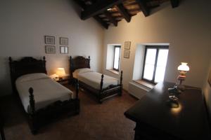 ToglianoVolpe Pasini - Wine and Rooms的一间卧室设有两张床和两个窗户。