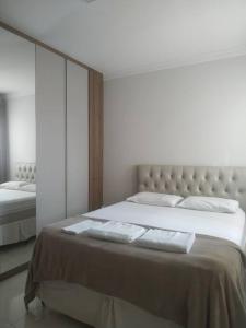 Ubáapartamento alto padrão (centro)的一间卧室配有一张大床和两个枕头