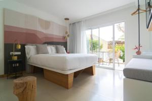 圣埃乌拉利亚Boutique Apartments Marsol Ibiza的一间带白色床的卧室和一个阳台