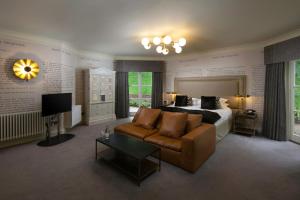戴德姆Talbooth House & Spa的一间卧室配有一张床、一张沙发和一台电视