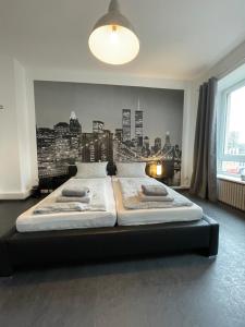 科布伦茨Schängelrooms的卧室配有两张床,墙上挂有城市壁画