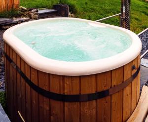 陶因Snowdonia Hideaway的庭院内的按摩浴缸,设有木栅栏