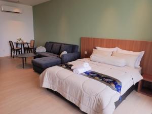 SematanRDHomeStay-RoxyBeachApt的一间卧室配有一张大床和一张沙发