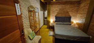 康塞高伊比蒂波卡IbitiAnJo - Suítes的一间设有两张床和砖墙的房间