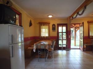 锡尔沃斯瓦里德Gaz69 vendégház的厨房配有桌子和冰箱