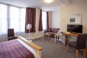 牛津巴特利酒店的酒店客房配有床、沙发和电视。