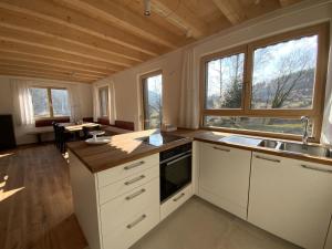 拜尔斯布龙Ferienhaus Baiersbronn LUG INS TAL的厨房配有白色橱柜、水槽和窗户。