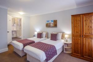 牛津巴特利酒店的酒店客房设有两张床和橱柜。