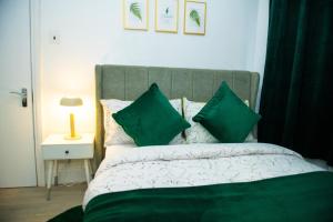 卢顿Newly Refurbished - Affordable Four Bedroom Semi-Detached House Near Luton Airport and Luton Hospital的一间卧室配有一张带绿色枕头的床