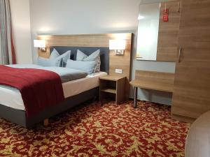 MarktlustenauLandgasthof Hotel Hirsch的酒店客房,配有一张铺有红地毯的床
