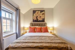 约克Middlethorpe Manor - No 3的一间卧室配有一张带橙色枕头的大床