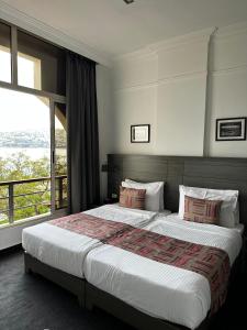 朱尼耶Bel Azur Hotel - Resort的一间卧室设有一张大床和大窗户