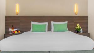 沙姆沙伊赫Domina Coral Bay Resort, Diving , Spa & Casino的一张白色的大床,带两个绿色枕头