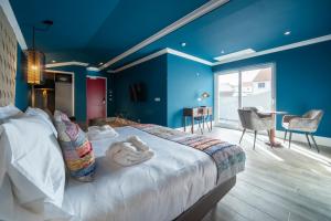 英雄港Açores Autêntico Boutique Hotel的一间卧室配有一张带蓝色墙壁的大床